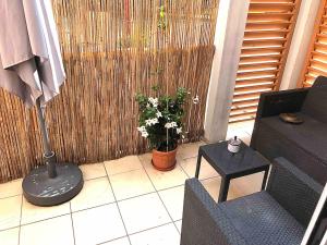 a patio with a couch and a table with a plant at Studio loft city center in Tarnos