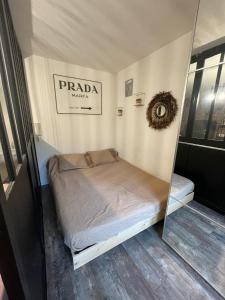 a small bed in a room with a mirror at Studio loft city center in Tarnos