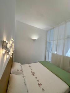 a small room with a bed and a window at Convers'Amo Home in Conversano