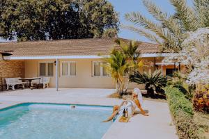 a house with two people playing in the swimming pool at Domiya Estate Ltd in Dodoma