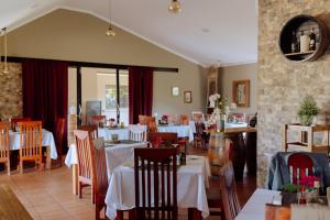 a dining room with white tables and chairs at Domiya Estate Ltd in Dodoma