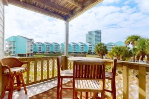 a balcony with a table and chairs and condos at Condo with partial bay view onsite fishing dock beach access & shared pool in Pensacola Beach