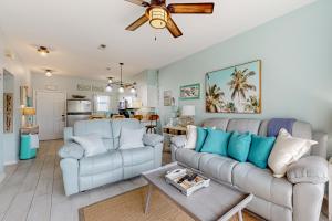 a living room with two couches and a table at Condo with partial bay view onsite fishing dock beach access & shared pool in Pensacola Beach +30 photos
