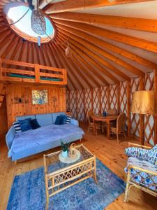 a living room with a blue couch in a yurt at Glamping Niebiańska Osada Jurty Dolnośląskie in Polanica-Zdrój +176 photos