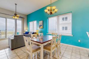 a dining room with a table and chairs and a couch at Beachfront Condo with amazing views shared pool and beach access in Navarre