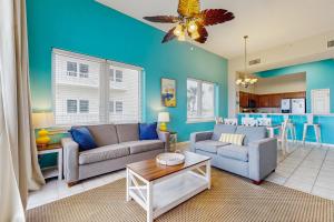 a living room with two couches and a kitchen at Beachfront Condo with amazing views shared pool and beach access in Navarre