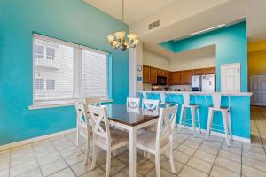 a dining room and kitchen with blue walls and a table and chairs at Beachfront Condo with amazing views shared pool and beach access in Navarre