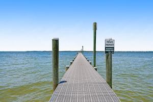 a pier in the water with a sign on it at Sound-Side Condo with Grill Deck & W&D and Shared Pool in Pensacola Beach
