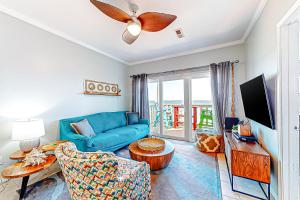 a living room with a blue couch and a table at Third-floor beachfront condo with views washer&dryer heated pool in Pensacola Beach