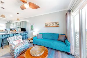 a living room with a blue couch and a table at Third-floor beachfront condo with views washer&dryer heated pool in Pensacola Beach