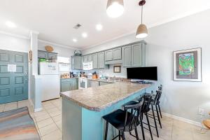 a kitchen with a large island with bar stools at Third-floor beachfront condo with views washer&dryer heated pool in Pensacola Beach +20 photos