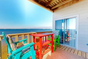 a deck with a table and chairs on a balcony at Third-floor beachfront condo with views washer&dryer heated pool in Pensacola Beach