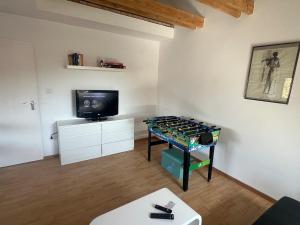 a room with a ping pong table and a tv at Bright and modern Apartment in Gröbenzell