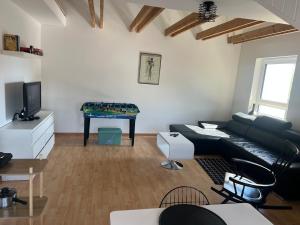 a living room with a black leather couch and a table at Bright and modern Apartment in Gröbenzell