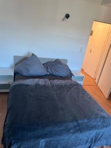 a bed with a blue comforter in a room at Bright and modern Apartment in Gröbenzell +5 photos