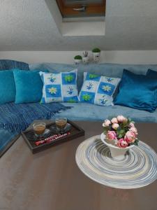 a living room with a couch and a table with flowers at Park Apartment in Kočani +77 photos
