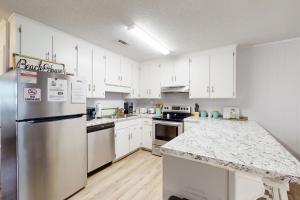 a kitchen with white cabinets and a stainless steel refrigerator at Dog-friendly duplex 2 blocks from beach with private yard AC & W&D in Panama City Beach