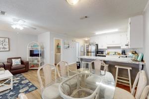 a kitchen and living room with a glass table and chairs at Dog-friendly duplex 2 blocks from beach with private yard AC & W&D in Panama City Beach