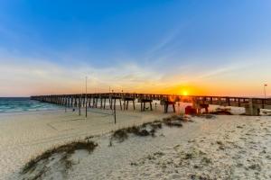 a pier on the beach at sunset at Dog-friendly duplex 2 blocks from beach with private yard AC & W&D in Panama City Beach