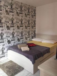 a bedroom with a bed with a wall covered in newspapers at Cozy Studio Bucharest in Bucharest