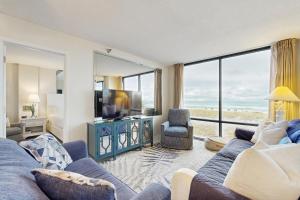 a living room with a blue couch and a large window at Beachfront condo shared pool large balcony and beach access in Navarre