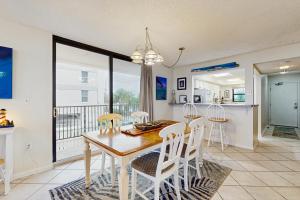 a dining room and kitchen with a table and chairs at Beachfront condo shared pool large balcony and beach access in Navarre +16 photos