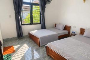 a bedroom with two beds and a window at Anh Dung Homestay in Ga Thừa Lưu