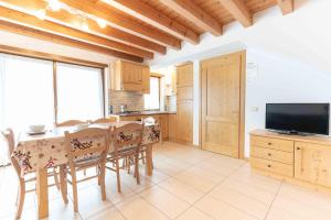 a kitchen with a table and chairs and a television at Green house in Mezzaselva +9 photos