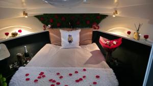 a bedroom with a bed with red roses on it at L'évasion - Pairi Daiza - Insolite in Chièvres