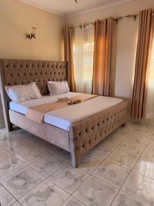 a bedroom with a large bed in a room at Kristina Gardens in Voi