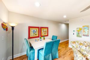 a dining room with a table and blue chairs at Cozy top-floor beachfront condo with pool pool spa & beach access in Perdido Key +20 photos