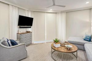 a living room with a couch and a tv at Stunning beachfront condo with shared pool & beach access in Santa Rosa Beach