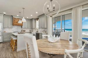 a kitchen and dining room with a table and chairs at Stunning beachfront condo with shared pool & beach access in Santa Rosa Beach