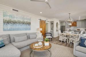 a living room with a couch and a table at Stunning beachfront condo with shared pool & beach access in Santa Rosa Beach