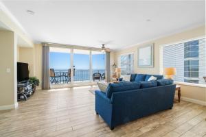 a living room with a blue couch and a balcony at Gorgeous cozy beachfront condo with pool pool spa & beach access in Perdido Key