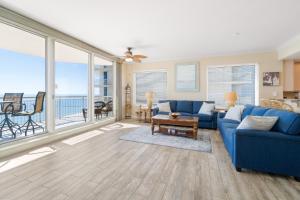 a living room with a blue couch and a balcony at Gorgeous cozy beachfront condo with pool pool spa & beach access in Perdido Key