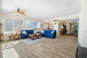 a living room with blue couches and a table at Gorgeous cozy beachfront condo with pool pool spa & beach access in Perdido Key +36 photos