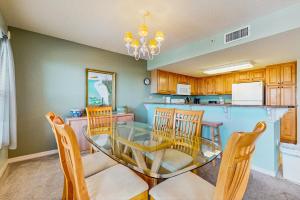a kitchen and dining room with a glass table and chairs at Beautiful beachfront condo with shared pool & beach access in Fort Walton Beach