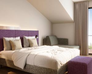 a bedroom with a large bed with a purple headboard at Engels Traumwerk in Wertach