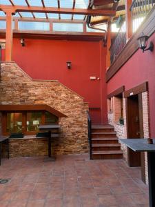 a building with a staircase and a red wall at hostal Saint James Way in Cacabelos