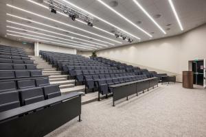 an empty lecture hall with black chairs and a podium at Thon Hotel Vika Atrium in Oslo