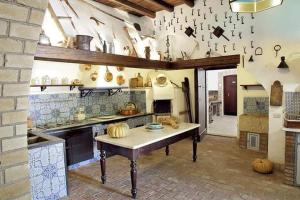 a large kitchen with a table in the middle at Fontana Murata Resort & spa in Borgo Regalmici