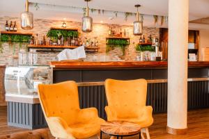 a bar with orange chairs in a restaurant at Guesthouse Solar do Mar in Silveira
