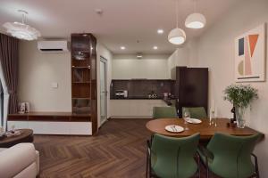 a kitchen and dining room with a table and chairs at HongHome Happy One Central in Ga Phú Văn