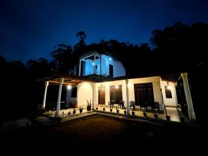 a house lit up at night with lights on it at Village Breeze Villa in Haputale