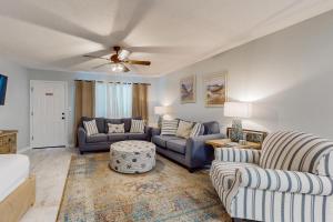 a living room with two couches and a ceiling fan at Beautiful coastal studio condo with pool in Santa Rosa Beach