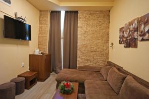 a living room with a couch and a tv at Apartmani u srcu grada in Zrenjanin