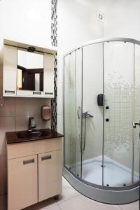 a bathroom with a glass shower and a sink at Apartmani u srcu grada in Zrenjanin +24 photos