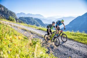 two people riding bikes down a dirt road at Landhotel Steindlwirt in Dorfgastein