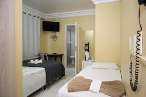 a hotel room with two beds and a bathroom at Diamantina Palace Hotel in Morro do Chapéu